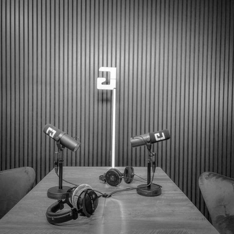 Podcaststudio digitalisierung 24/7 Zwei Mikrofone und zwei Kopfhörer auf einem Tisch in einem modernen Raum.