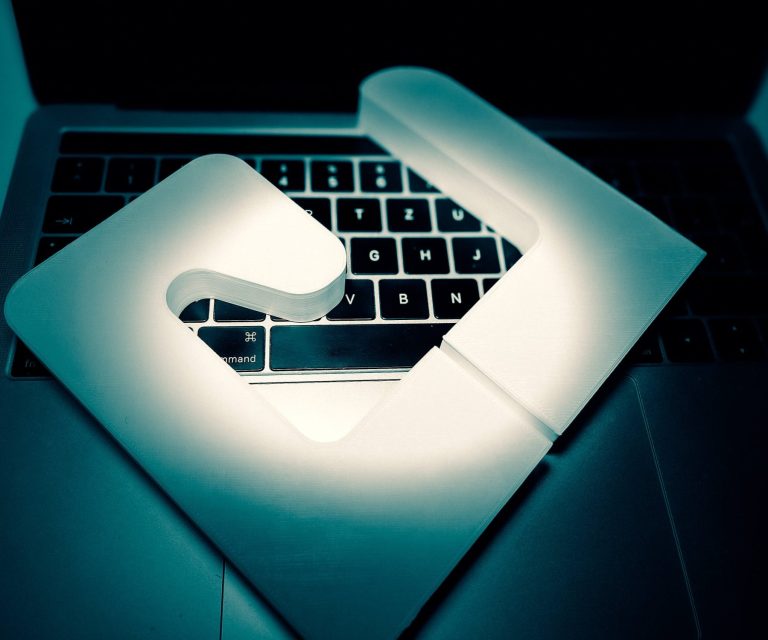 Weiße Form eines "G" auf einer Laptop-Tastatur mit Hintergrundbeleuchtung.